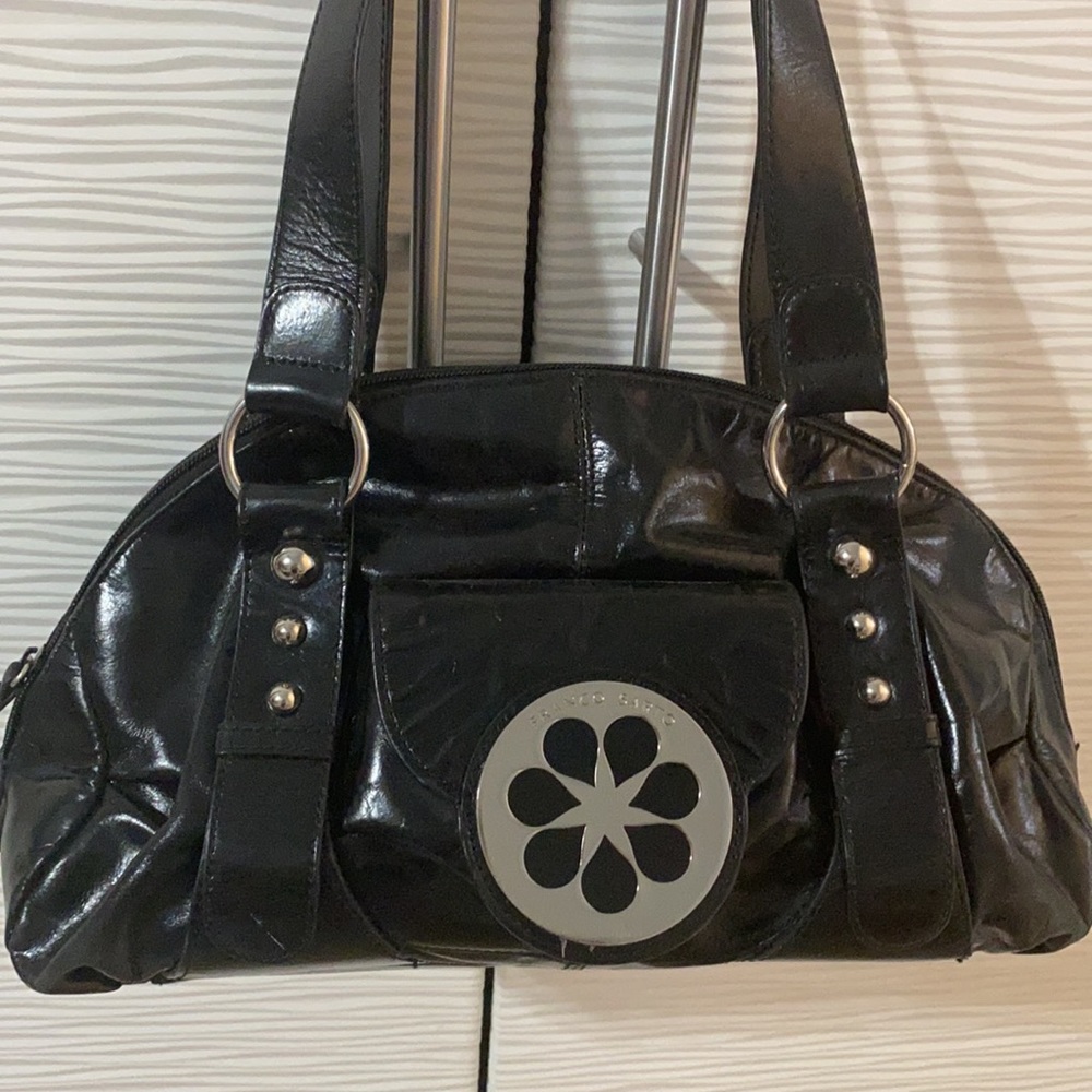 Franco Sarto black leather purse with chrome flier design on the front pocket